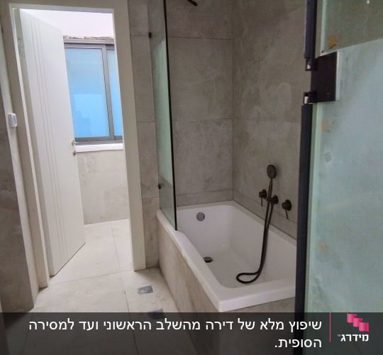 חדר אמבטיה עם אמבטיה ודלת פתוחה